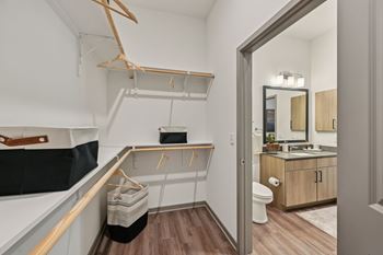 A bathroom with a toilet, sink, and mirror. at The Concord Luxury Apartments, Sarasota, FL